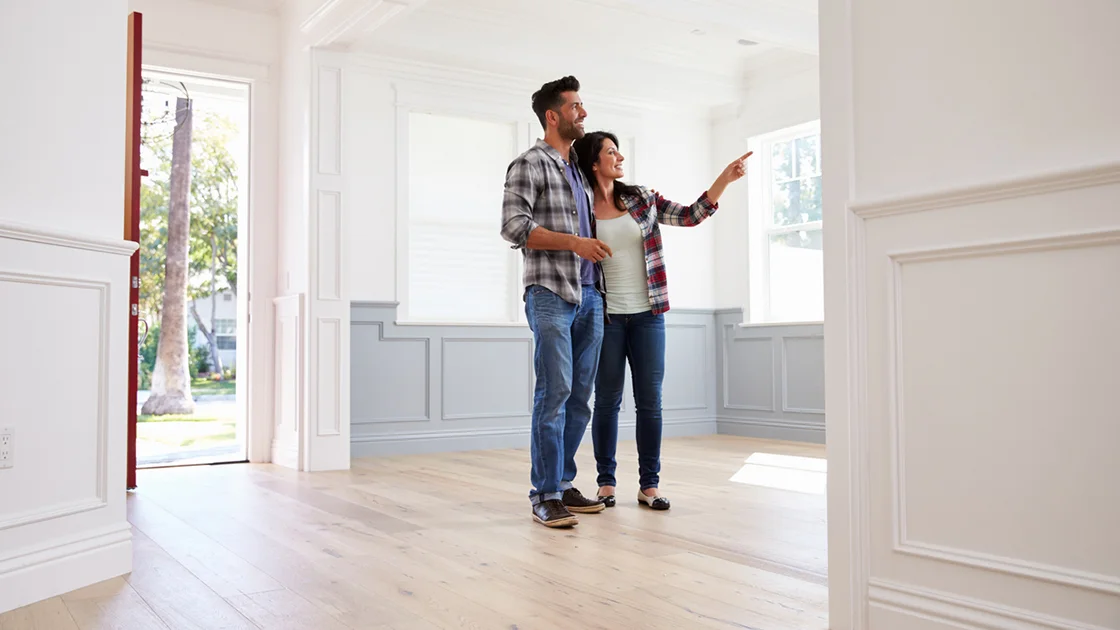 Happy homeowner admiring freshly painted walls during the final walkthrough